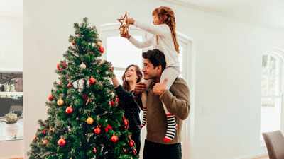семья наряжает елку и создает новогоднее настроение в квартире