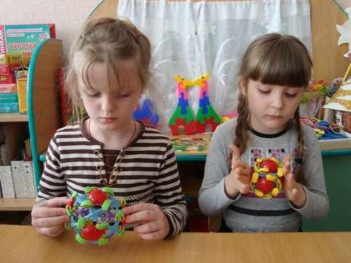 Две девочки крутят игрушки с фигурками