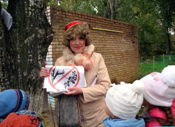 Педагог в костюме Лисы Алисы показывает детям запрещающий знак