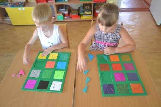 Двое детей складывают квадраты из разных геометрических фигур