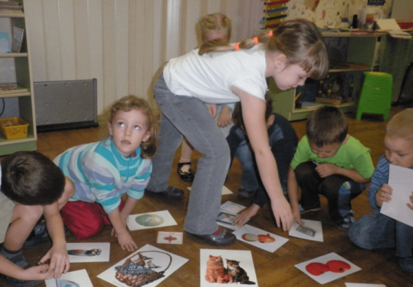 Дошкольники работают с картинками, разложенными на полу