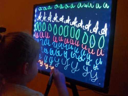 Девочка пишет буквы на led-доске
