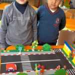 Два мальчика стоят у макета проезжей части