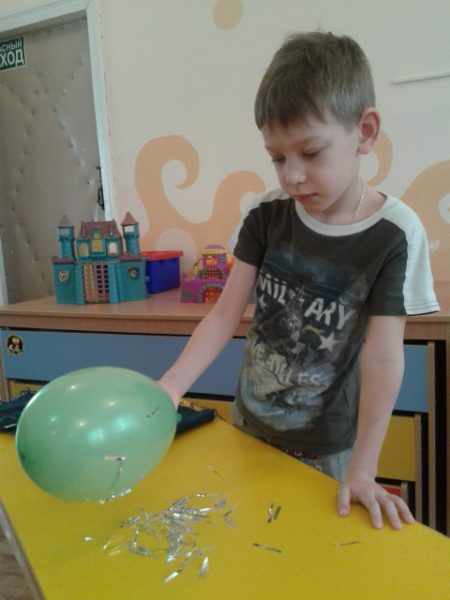 Мальчик проводит эксперимент с воздушным шариком и фольгой