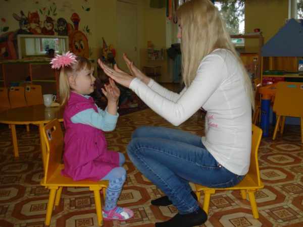 Девочка и педагог играют в «Ладушки»