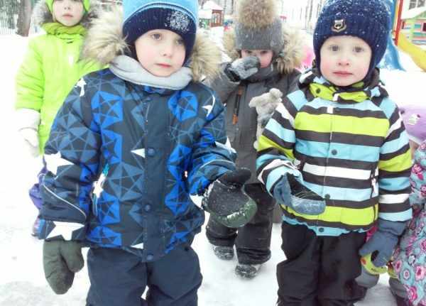 Четыре ребёнка в зимней одежде стоят на снегу