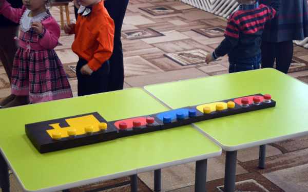 Поезд-конструктор с разноцветными вагонами на столе