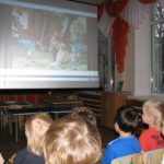 Дети смотрят мультфильм на большом экране