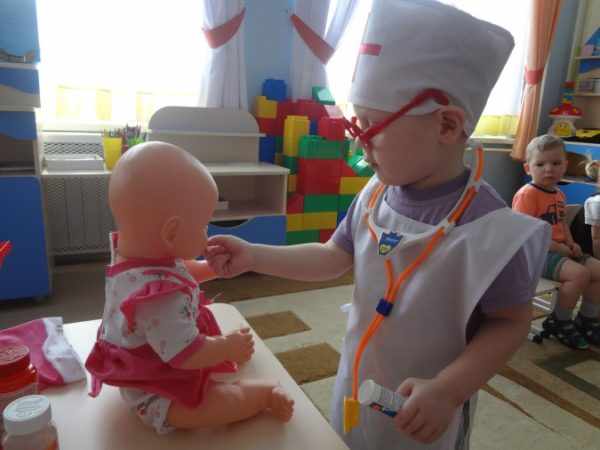 Ребёнок в роли врача лечит куклу