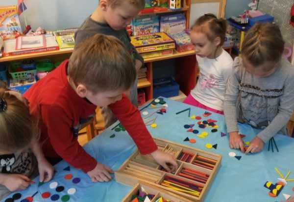 Дети раскладывают счётные палочки и плоские геометрические фигуры