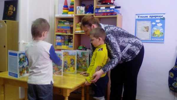 Воспитатель показывает детям книжки о профессиях