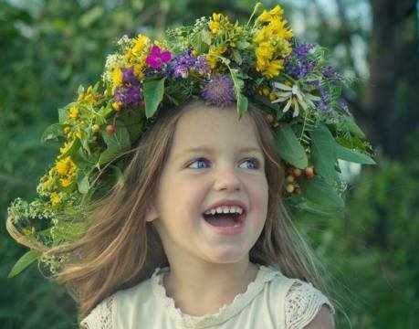 Улыбающаяся девочка в венке из цветов