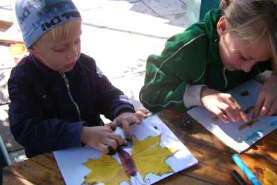 Дети делают аппликацию из листьев