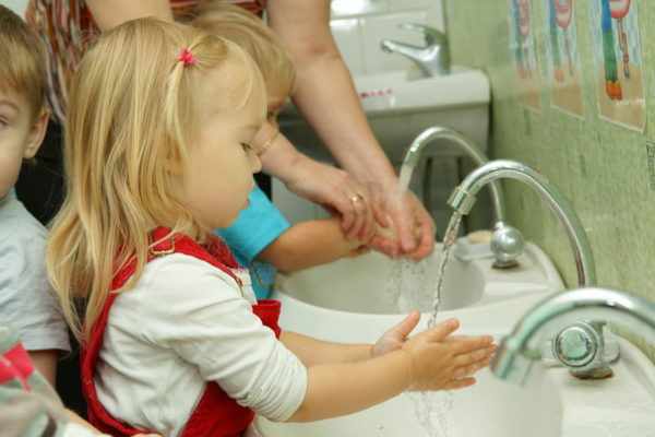 Воспитатель показывает малышам, как мыть руки