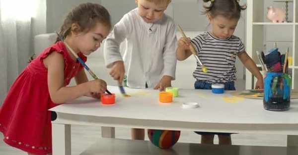 Трое детей рисуют красками