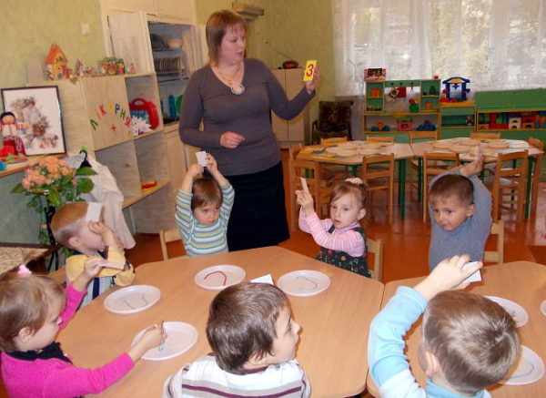 Воспитательница показывает детям цифру три