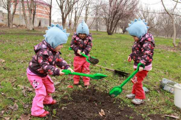 Трое детей копают яму лопатками