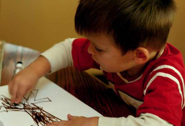 Мальчик рисует фломастером