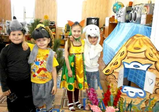 Дети в костюмах стоят на фоне декораций