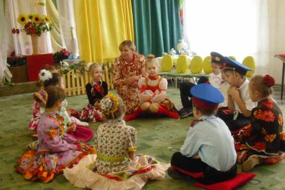 Дети и педагог в костюмах участвуют в досуге «Казачьи посиделки»
