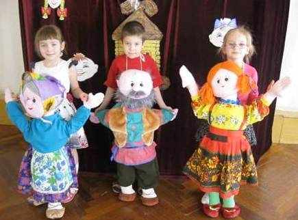 Две девочки и мальчик с куклами с куклами на фартуке