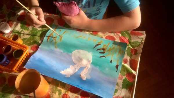 Ребёнок рисует белого лебедя на тонированной основе (два оттенка голубого)