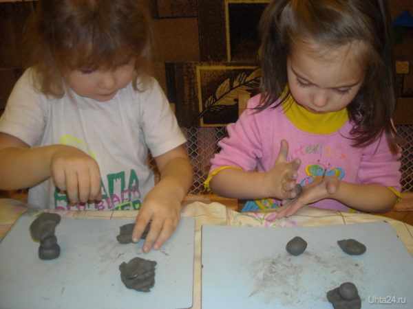 Две девочки лепят из глины