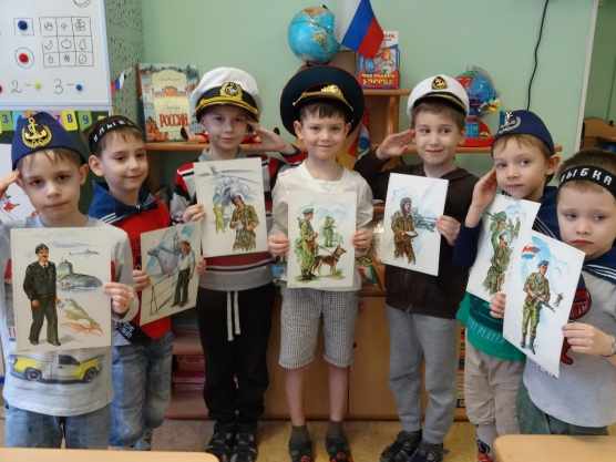 Дети стоят с картинками военных разных родов войск
