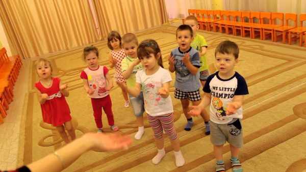 Малыши делают движения руками, подражая педагогу