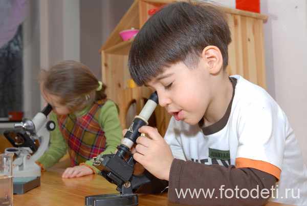 Мальчик и девочка работают с микроскопами