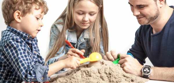 Папа и дети играют в кинетический песок