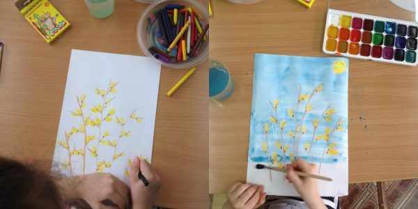 Ребёнок рисует веточки восковыми мелками, а затем закрашивает фон голубой акварелью
