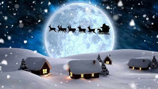 Дед Мороз летит по небу в повозке с оленями