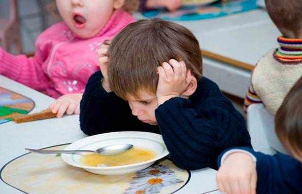 Перед мальчиком стоит тарелка супа, он не хочет есть