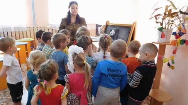 Дети стоят вокруг воспитательницы