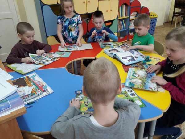 Дети за круглым столом читают книги