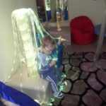 Ребёнок сидит в фиброоптическом светильнике