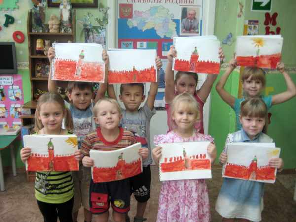 Дети стоят, держа в руках рисунки с изображениями Кремля