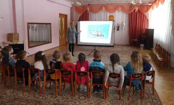 Педагог показывает детям военную технику на проекторе