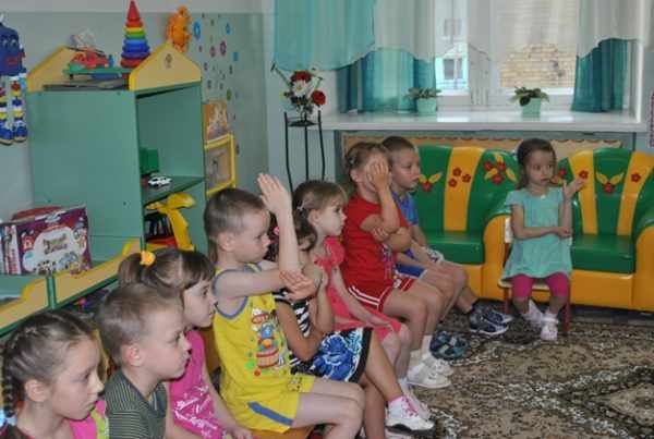 Дети сидят с поднятой рукой для ответа