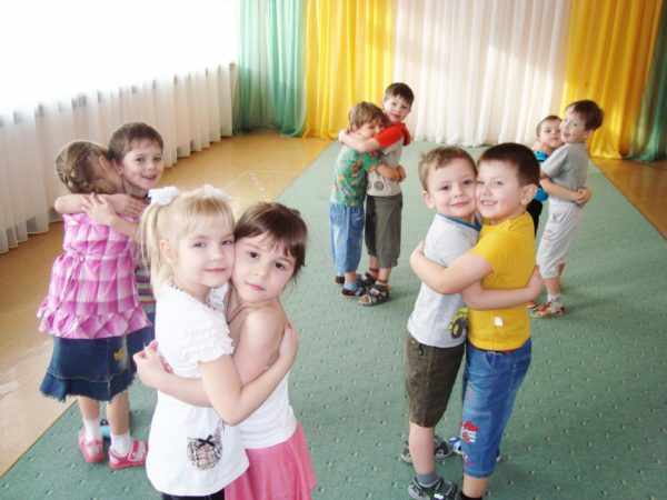 Дети обнимаются по парам в танцевальном зале