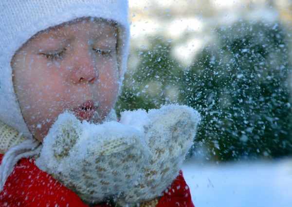 Мальчик дует на снег