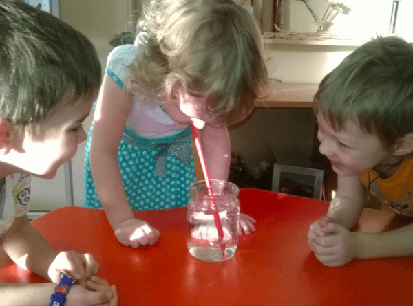 Трое детей проводят опыт «Буря в стакане»