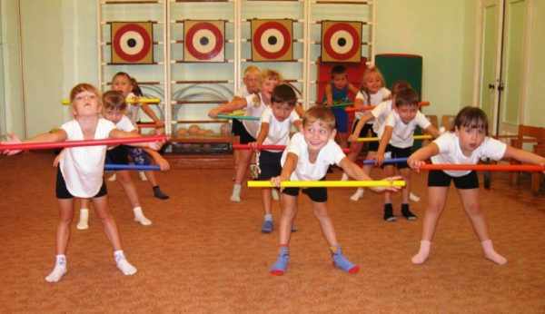 Дети выполняют упражнение с обручами в спортивном зале