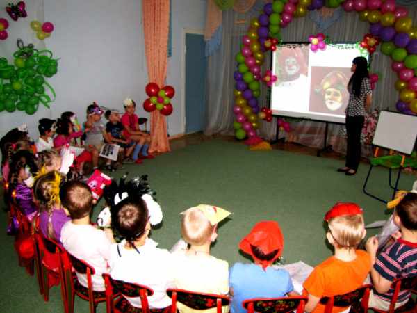 Воспитатель демонстрирует презентацию детям в костюмах