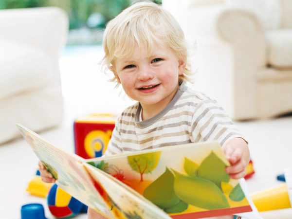Дошкольник 3–4 лет изучает книгу с картинками
