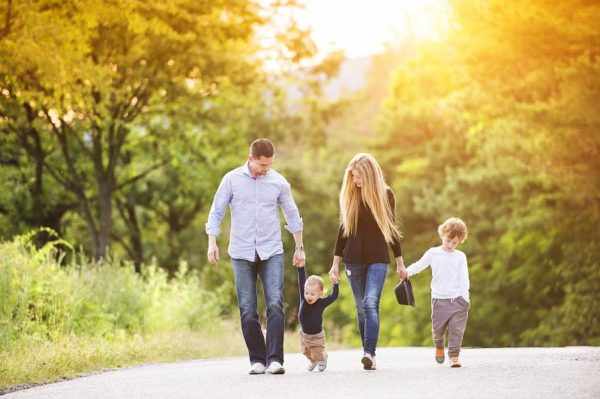 Мама, папа и два ребёнка на прогулке в парке