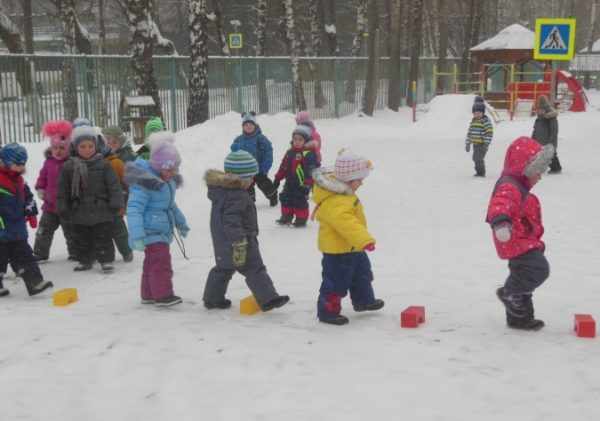 Дети зимой идут вдоль выложенной кубиками дорожки