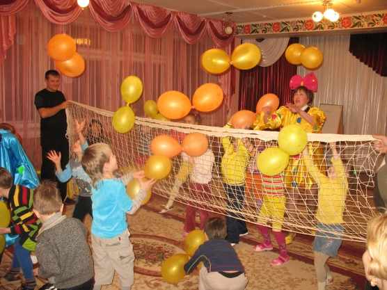 Дети и воспитатель играют с воздушными шариками