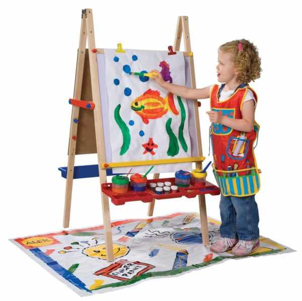 Девочка рисует красками на мольберте